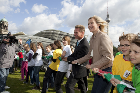 Bettina Wulff stellt gemeinsam mit Berliner Kindern einen luftgefüllten Tropenbaum auf dem Berliner Schlossplatz auf