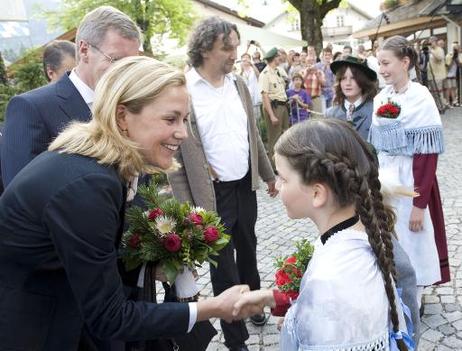 Bundespräsident Christian Wulff und seine Frau Bettina werden von Mädchen in Tracht mit Blumen in Oberammergau begrüßt (r.: Christian Stückl, Spielleiter der Passionsspiele).