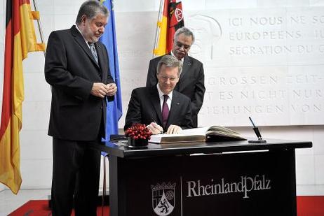 Antrittsbesuch in Rheinland-Pfalz - Bundespräsident Christian Wulff (M.) trägt sich in der Staatskanzlei in das Goldene Buch des Landes ein (l.: Kurt Beck, Ministerpräsident von Rheinland-Pfalz; r.: Innenminister des Landes).