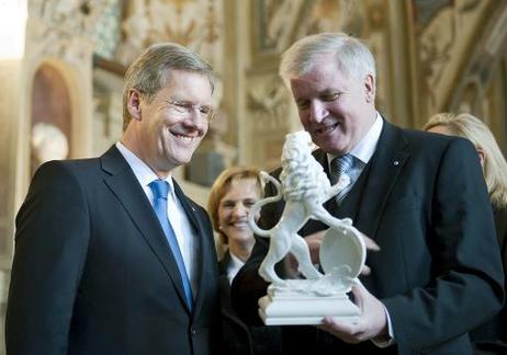 Antrittsbesuch in Bayern - Bundespräsident Christian Wulff nimmt von Horst Seehofer, Ministerpräsident Bayerns (r.), ein Gastgeschenk entgegen (Bayerischer Löwe aus der Nymphenburger Porzellanmanufaktur).