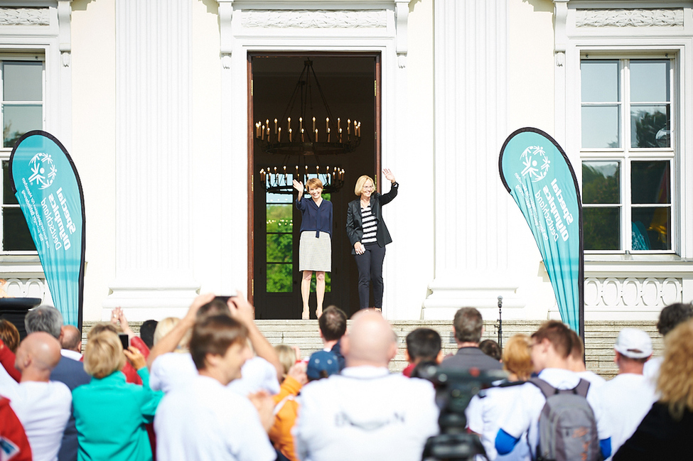 Elke Büdenbender begrüßt gemeinsam mit der Präsidentin Special Olympics Deutschland, Christiane Krajewski, die Läuferinnen und Läufer am Schlossportal zum Auftakt des Special Olympics Fackellaufs