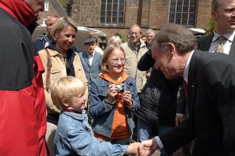 Bundespräsident Horst Köhler begrüßt während des Stadtrundgangs einen kleinen Jungen.