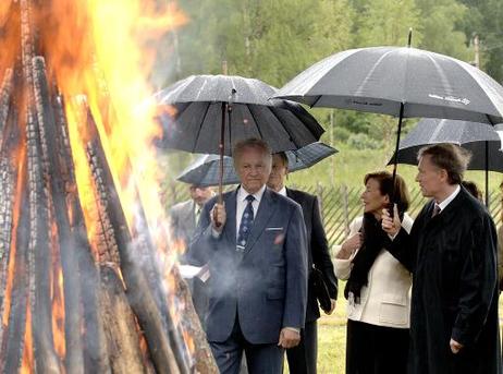 Bundespräsident Horst Köhler (r.) und seine Frau Eva Luise mit Arnold Rüütel, Staatspräsident Estlands, (mit Regenschirmen) am Willkommensfeuer des Restaurants Altja Korts.