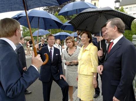 Bundespräsident Horst Köhler (r.) und seine Frau Eva Luise mit Großherzogin Maria Teresa und Großherzog Henri (M.) unter Regenschirmen beim gemeinsamen Stadtrundgang. Gemeinsam eröffnen sie am Abend die neue Philharmonie Luxemburg.