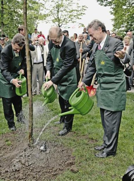 Bundespräsident Horst Köhler (r.) und Günther H. Oettinger, Ministerpräsident Baden-Württemberg(l.), gießen einen von ihnen gepflanzten Baum (M.: Erzbischof Erwin Josef Ender, Apostolischer Nuntius, Doyen des Diplomatischen Korps; alle mit Schürzen).