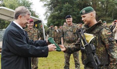 Bundespräsident Horst Köhler erhält von Fahnenjuncker Andreas May ein Barett der Panzergrenadiertruppe als Gastgeschenk.