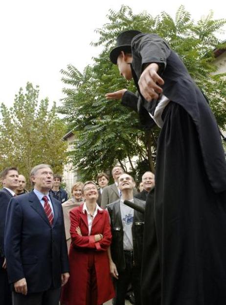 Bundespräsident Horst Köhler mit einem 'Stelzenmann' während eines Besuchs des Projektes RAW-Tempel e.V.