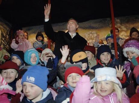 Bundespräsident Horst Köhler (winkend) mit Kindern des evangelischen und katholischen Kindergartens auf dem Weihnachtsmarkt von Eisleben.