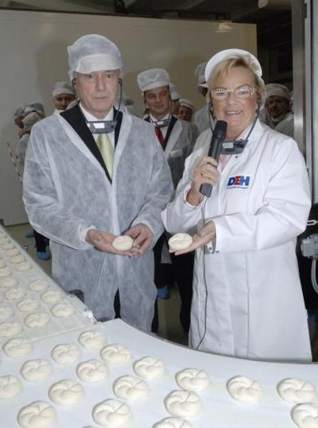 Bundespräsident Horst Köhler und die Unternehmerin Doris Entrup an einem Fließband mit Brötchen der Tiefkühlbackwaren-Firma.