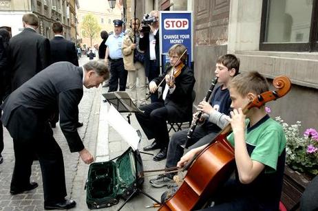 Bundespräsident Horst Köhler (bezahlt für die Musik junger Straßenmusiker) beim Rundgang durch die Warschauer Altstadt.