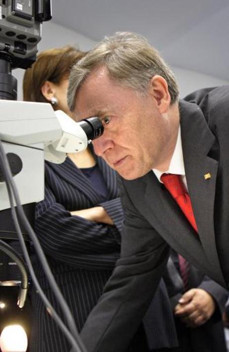 Bundespräsident Horst Köhler (blickt durch ein Mikroskop) und seine Frau Eva Luise lassen sich im Bundesinstitut für Risikobewertung die Durchführung eines HET-CAM-Tests erklären.