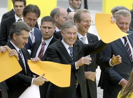 Bundespräsident Horst Köhler (M.) mit einem Teil des Eröffnungsbandes nach der Eröffnung der Neuen Landesmesse Stuttgart (l.: Günther H. Oettinger, Ministerpräsident von Baden-Württemberg).