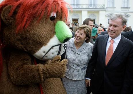 Bundespräsident Horst Köhler und seine Frau Eva Luise im Gespräch mit einem "Maskottchen".
