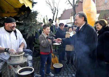 Bundespräsident Horst Köhler und seine Frau Eva Luise (beide r.) im Gespräch mit einem Töpfer auf dem Adventsmarkt in Luckau.