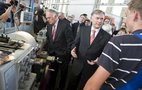 Bundespräsident Horst Köhler (M.) im Gespräch mit einem Auszubildenden an einer Drehmaschine beim Europäischen Bildungswerk für Beruf und Gesellschaft (l.: Wolfgang Böhmer, Ministerpräsident von Sachsen-Anhalt).