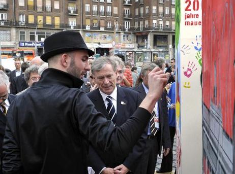 Bundespräsident Horst Köhler (M.) im Gespräch mit einem Künstler bei einem Besuch des multimedialen Ausstellungspavillons "20 Jahre Freiheit: Deutschland sagt Danke".