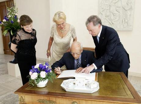 Altbundespräsident Walter Scheel (trägt sich in das Gästebuch ein) am Rande eines Empfangs anlässlich seines 90. Geburtstages im Schloss Bellevue (v.l.: Eva Luise Köhler; Barbara Scheel; r.: Bundespräsident Horst Köhler).