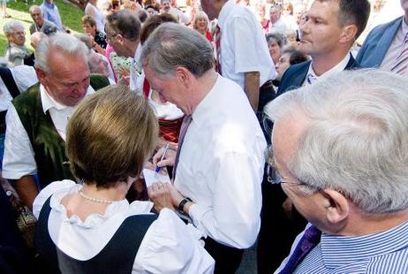 Bundespräsident Horst Köhler (M.) gibt ab Rande eines Dorffestes Autogramme.