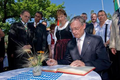 Bundespräsident Horst Köhler trägt sich in das Gästebuch der Gemeinde Seeg ein (l. daneben: Eva Luise Köhler).