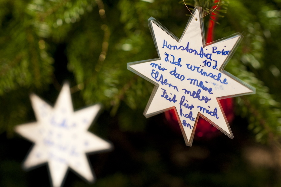 Wünsche von Kindern einer Berliner Schule auf den Sternen am Weihnachtsbaum in Schloss Bellevue