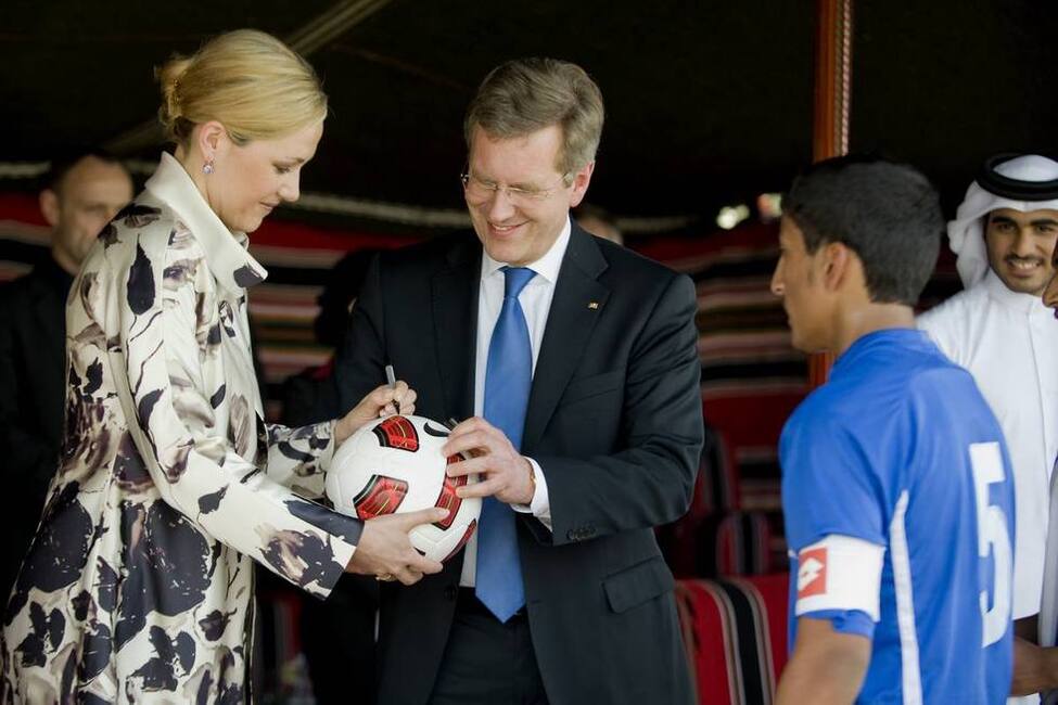Bundespräsident Christian Wulff und seine Frau Bettina Wulff signieren einen Fußball für katarische Jugendmannschaften