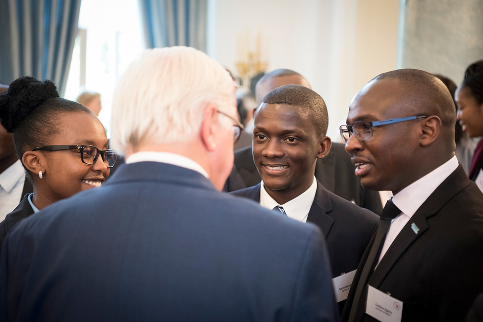 Bundespräsident Frank-Walter Steinmeier tauscht sich mit Stipendiatinnen und Stipendiaten von 'Afrika kommt!' während eines Empfangs in Schloss Bellevue aus.