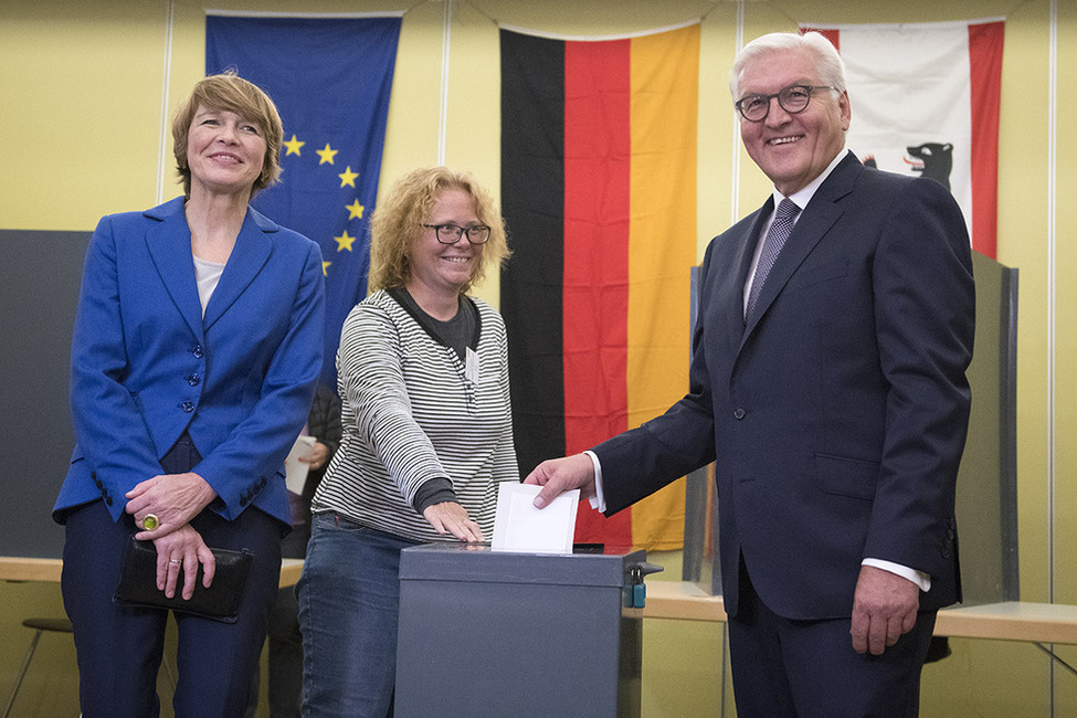 Bundespräsident Frank-Walter Steinmeier wirft seine Wahlscheine in die Wahlurne bei seiner Stimmabgabe bei der Bundestagswahl in der Nord-Grundschule in Berlin-Zehlendorf