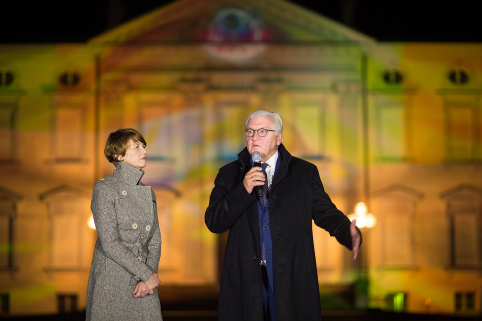 Bundespräsident Frank-Walter Steinmeier hält eine Ansprache neben Elke Büdenbender bei der Eröffnung der Projektion zum Sonder-Award 'Demokratie' beim Festival of Lights 2017 auf der Fassade von Schloss Bellevue