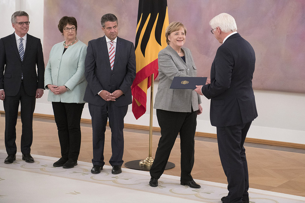 Bundespräsident Frank-Walter Steinmeier überreicht der Bundeskanzlerin die Entlassungsurkunde