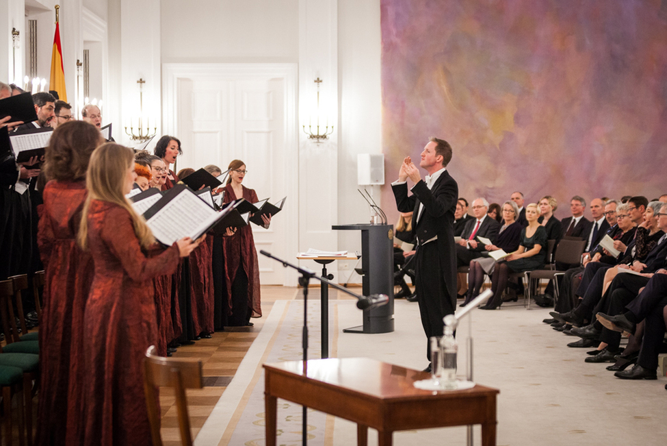 Bundespräsident Frank-Walter Steinmeier lauscht dem Adventskonzert mit dem RIAS-Kammerchor unter Chefdirigent und künstlerischerem Leiter Justin Doyle im Großen Saal von Schloss Bellevue 