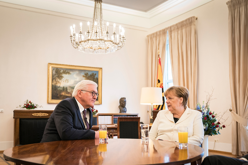 Bundespräsident Frank-Walter Steinmeier im Gespräch mit Bundeskanzlerin Angela Merkel anlässlich der Aushändigung der Ernennungsurkunde im Amtszimmer von Schloss Bellevue