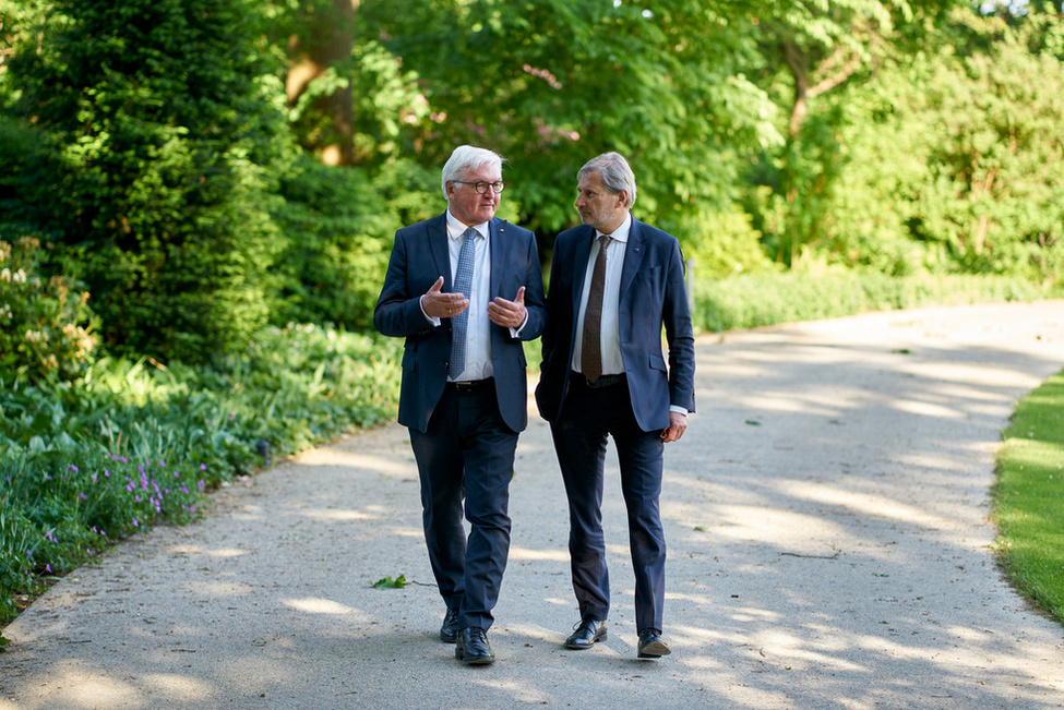 Bundespräsident Frank-Walter Steinmeier im Gespräch mit Johannes Hahn, EU-Kommissar für Europäische Nachbarschaftspolitik und Erweiterungsverhandlungen im Park von Schloss Bellevue 