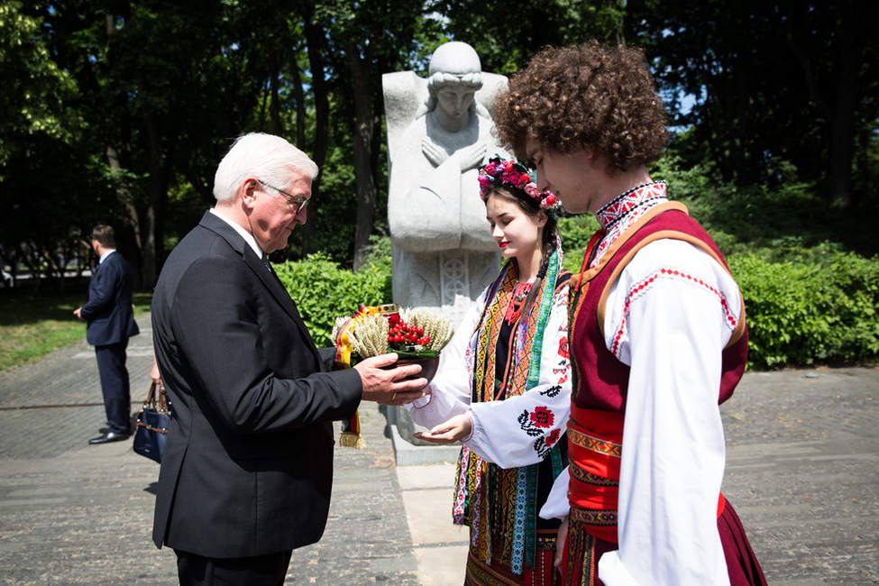 Bundespräsident Frank-Walter Steinmeier nimmt eine Getreideschale von Vertretern in ukrainischer Tracht an der Holodomor-Gedenkstätte in Kiew anlässlich seines offiziellen Besuchs in der Ukraine entgegen