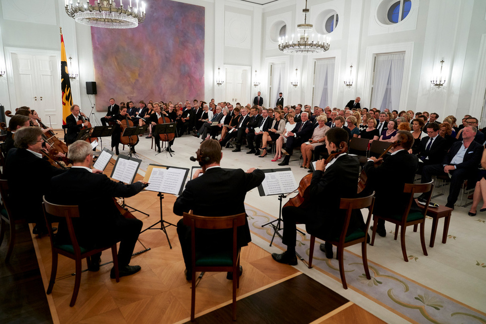 Bundespräsident Frank-Walter Steinmeier und Elke Büdenbender lauschen gemeinsam mit ihren Gästen dem Konzert der '12 Cellisten der Berliner Philharmoniker' im Großen Saal von Schloss Bellevue 