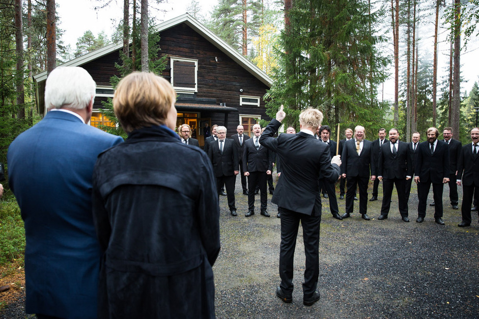 Bundespräsident Frank-Walter Steinmeier und Elke Büdenbender verfolgen die Darbietung des Schrei-Chors Huutajat beim Besuch des Pehkolanlampi-Hauses in Oulu während des Staatsbesuchs in Finnland