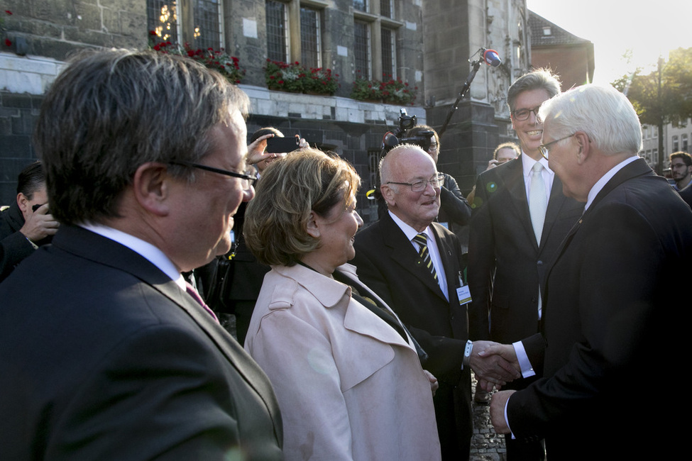 Bundespräsident Frank-Walter Steinmeier wird vom Dompropst, Manfred von Holtum, und von Armin Laschet, Ministerpräsident von Nordrhein-Westfalen, aus Anlass des 40. Jahrestages des UNESCO Weltkulturerbes Aachener Dom vor dem Rathaus in Aachen begrüßt