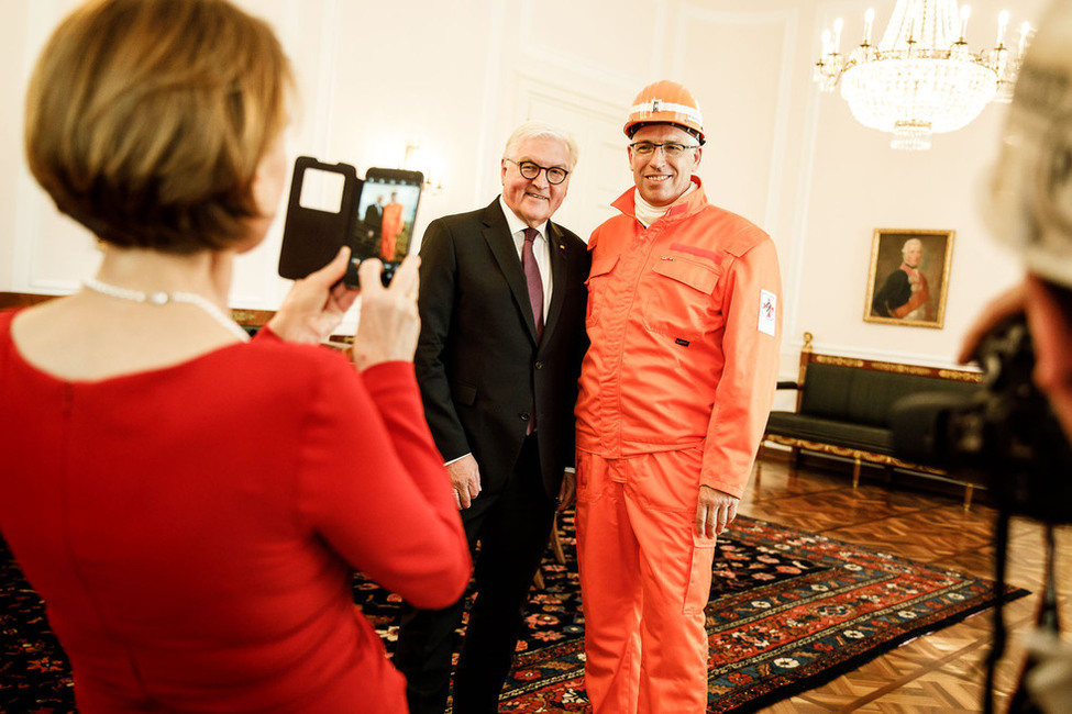 Bundespräsident Frank-Walter Steinmeier und Elke Büdenbender machen Fotos mit Mitarbeitern der Grubenwehr nach der Übergabe des letzten in Deutschland geförderten Stücks Steinkohle in Schloss Bellevue