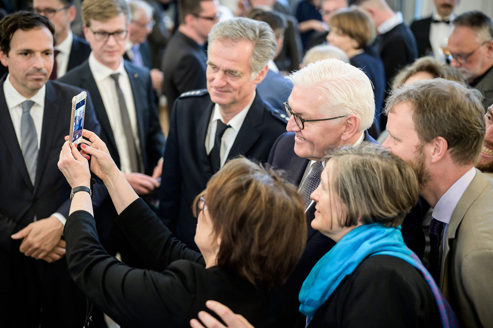 Bundespräsident Frank-Walter Steinmeier macht Fotos mit seinen Gästen beim Empfang im Anschluss an die Ordensverleihung 
