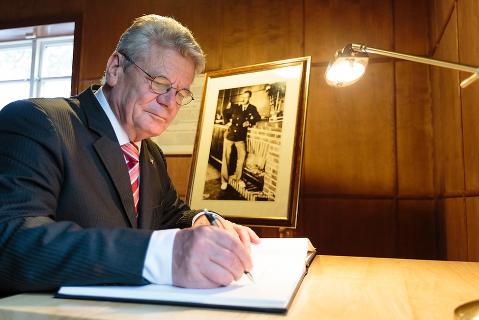 Bundespräsident Joachim Gauck trägt sich im Thomas-Mann-Museum in Nida ins Gästebuch ein