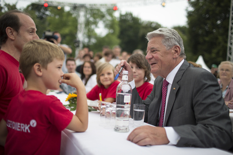 Bundespräsident Joachim Gauck im Gespräch mit einem jungen Gast auf dem Bürgerfest