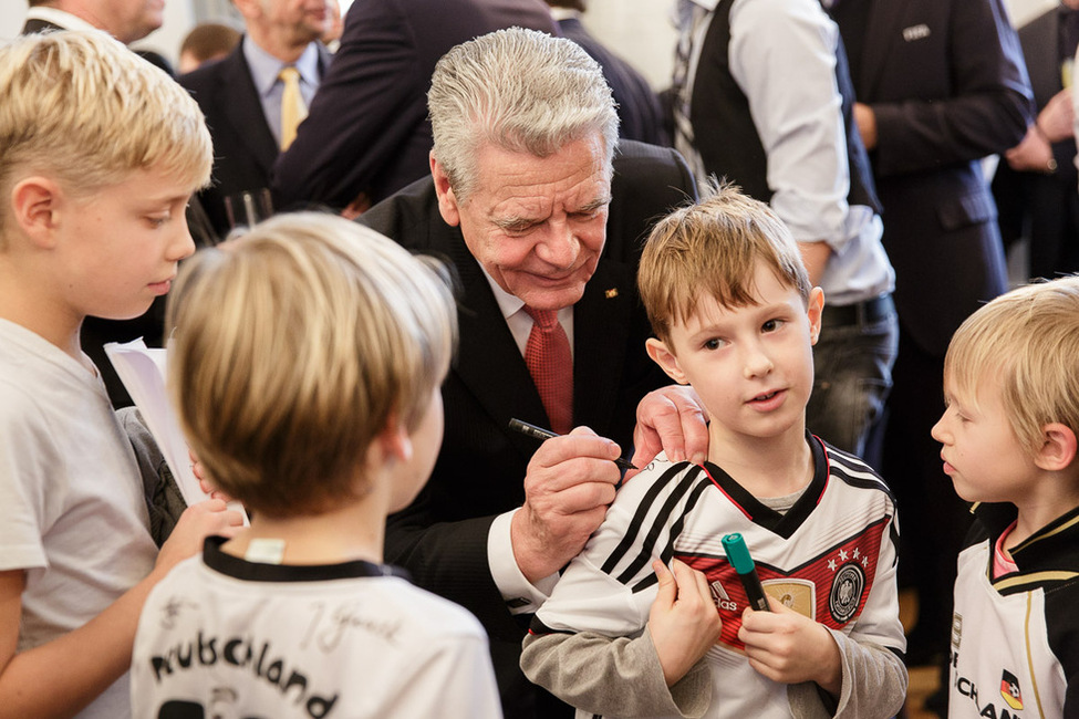 Bundespräsident Joachim Gauck gibt Autogramme für Nachwuchsfußballer beim Empfang in Schloss Bellevue anlässlich der Verleihung des Silbernen Lorbeerblattes an die Deutsche Fußballnationalmannschaft