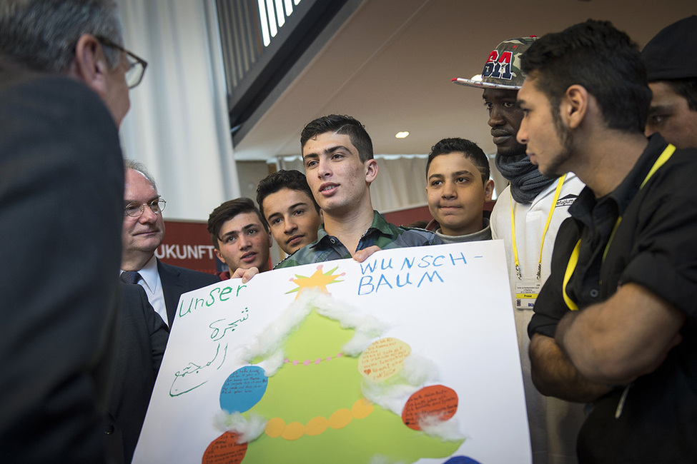 Bundespräsident Joachim Gauck im Gespräch mit unbegleiteten minderjährigen Flüchtlingen, die einen 'Weihnachtswunschbaum' in der Katholischen Universitätskirche St. Petri überreichen