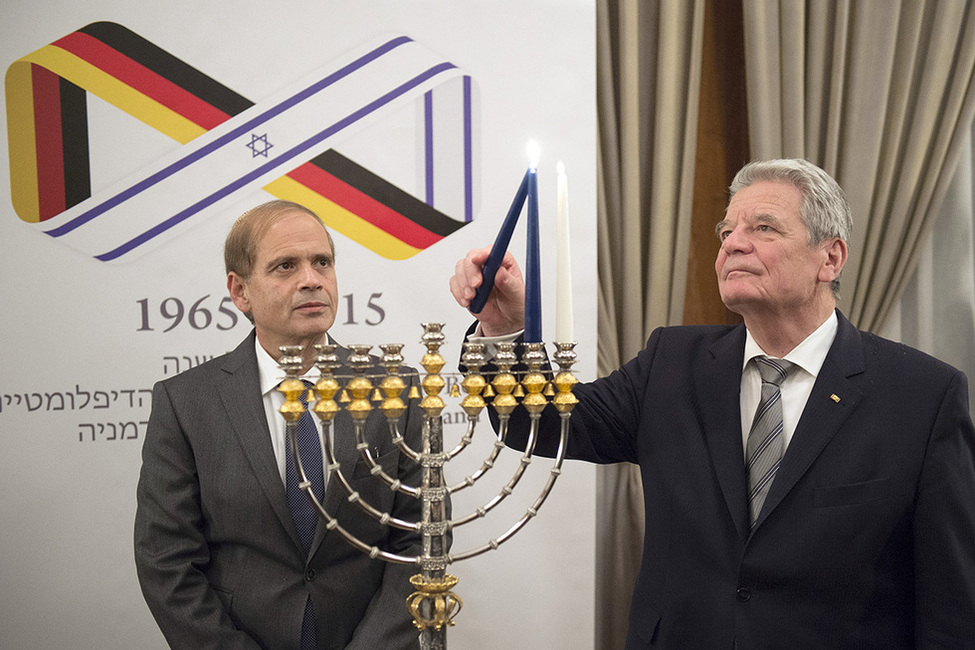 Bundespräsident Joachim Gauck entzündet den neunarmigen Leuchter in der israelischen Botschaft anlässlich des Chanukka-Empfangs, gegeben vom israelischen Botschafter