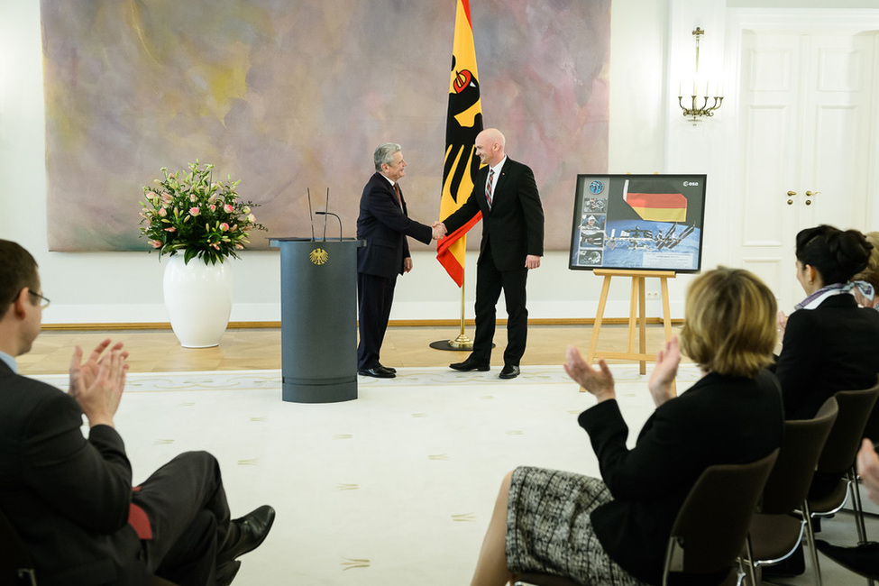 Bundespräsident Joachim Gauck erhält von dem Astronauten Alexander Gerst, dem er das Verdienstkreuz 1. Klasse im Großen Saal von Schloss Bellevue verliehen hat, ein Geschenk