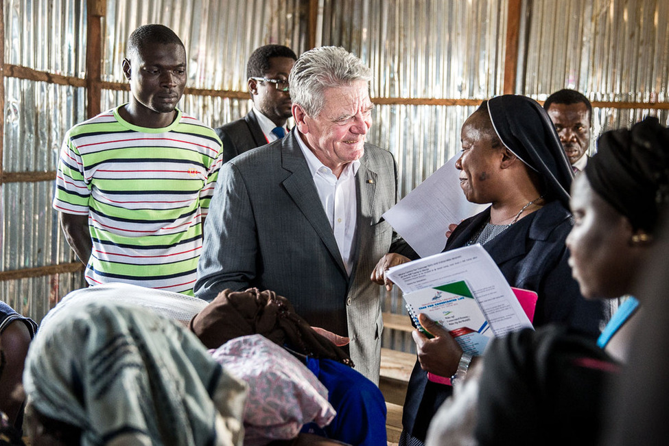 Bundespräsident Joachim Gauck beim Austausch mit der Frauengruppe des Flüchtlingslagers New Kuchigoro während seines Rundgangs durch das Flüchtlingslager in der Nähe von Abuja anlässlich seines offiziellen Besuchs in Nigeria