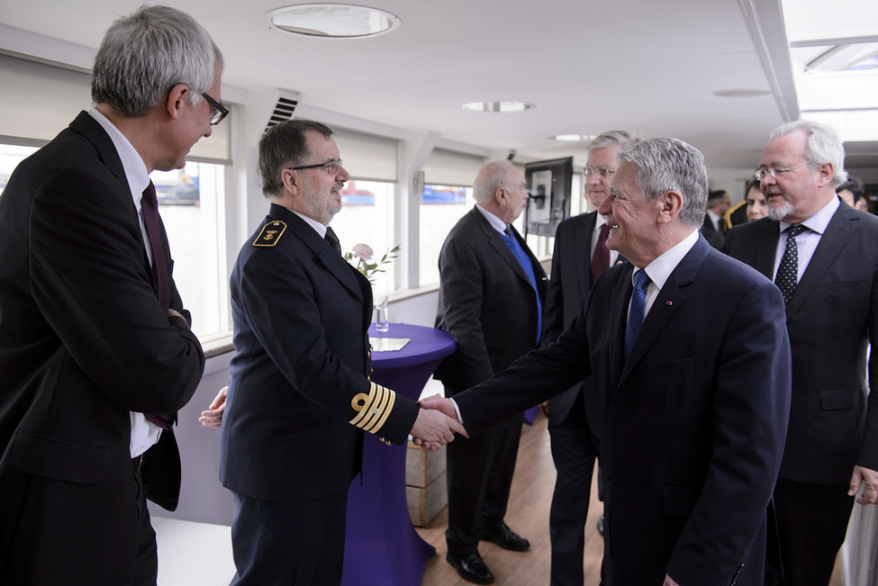 Bundespräsident Joachim Gauck wird bei der Hafenrundfahrt auf dem Schiff 'Le Formidable' in Antwerpen vom Kapitän begrüßt 