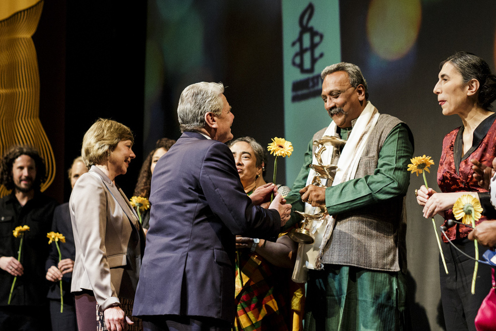 Bundespräsident Joachim Gauck und Daniela Schadt gratulieren Preisträger Henri Tiphagneim anlässlich der Verleihung des 8. Amnesty International Menschenrechtspreises auf der Bühne des Maxim Gorki Theaters in Berlin 