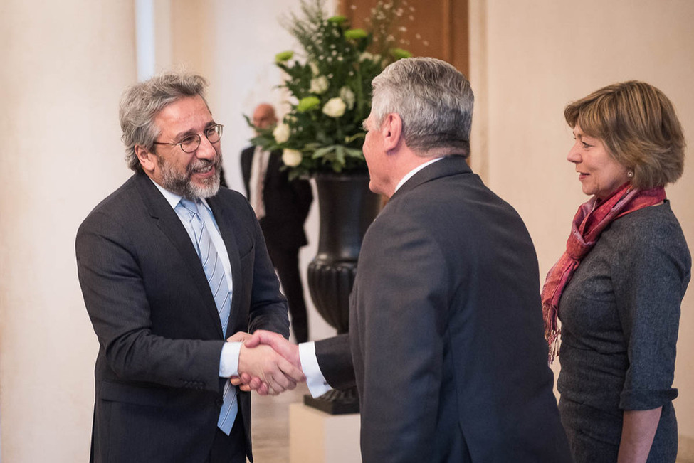 Bundespräsident Joachim Gauck und Daniela Schadt begrüßen den ehemaligen Chefredakteur der türkischen Tageszeitung Cumhuriyet, Can Dündar, in der Eingangshalle von Schloss Bellevue
