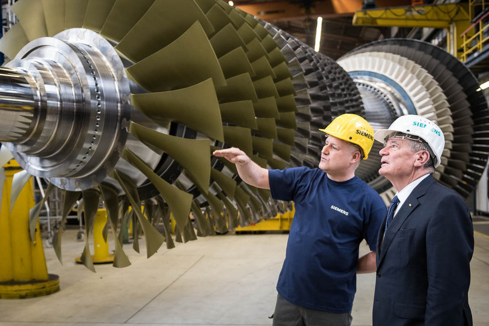 Bundespräsident Joachim Gauck im Austausch mit Turbinenschlosser Peter Schiffel während des Rundgangs im Gasturbinenwerk von Siemens in Berlin