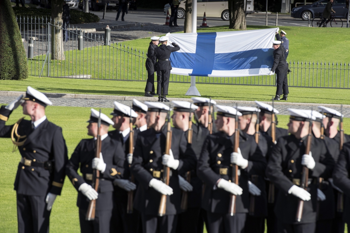 Soldiers hold a Finnish flag during military honors in front of Bellevue Palace